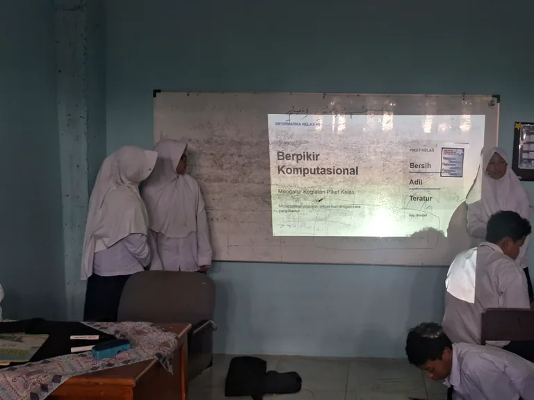 Siswa mempresentasikan materi pelajaran di depan papan tulis kelas.